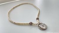 Full view of pearl necklace showing heart lock and mesh beads