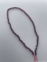 Full view of the garnet bead strand showing length and overall condition