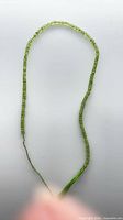 Full view of peridot bead strand laid out in loop