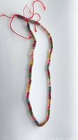 Full view of the 16-inch multicolour tourmaline bead strand on red thread