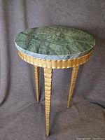 full view of side table showing green marble top, gold apron and three legs
