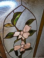 Close-up of floral stained glass design highlighting colors and crack