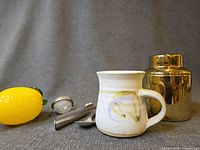 Group shot showing mug, canister, two infusers, spoon with lemon for scale