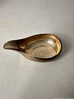 side view of sterling silver gravy boat showing shape and finish