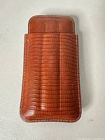 Front view of one embossed brown leather slip case