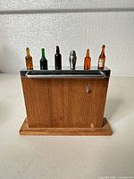 Front view of wooden stand with six picks inserted