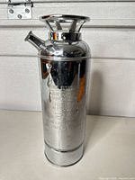 Full view of chrome fire-extinguisher style shaker standing upright