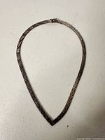 Full view of sterling silver woven necklace laid flat