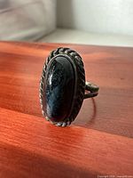 Front view of sterling silver ring showing oval black onyx and rope bezel