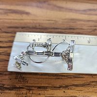Curved rhinestone spray brooch with ruler for scale