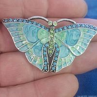 Front view of butterfly brooch showing enamel colors and stone accents
