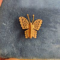 front view of gold-plated butterfly brooch on fabric
