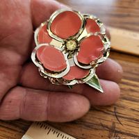 Front view showing coral pink enamel flower design and scale