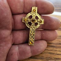 Brooch front view in hand showing design and stones