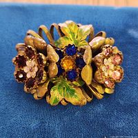 Front view showing floral rhinestone design and enamel leaves