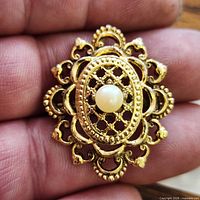 front view showing filigree design and faux pearl