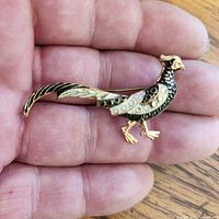 Full view of bird brooch in hand, shows overall shape and size