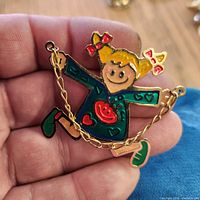 Front view of enamel child figure brooch