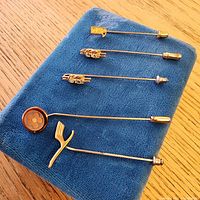 All five stick pins on blue pad showing head designs and clutches