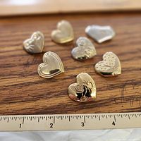 All seven heart brooches front view showing variety of designs and overall condition