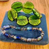 Both bracelets displayed on blue velvet pad showing bead styles and colours