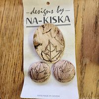 Front of card displaying oval brooch and two round earrings with leaf motif