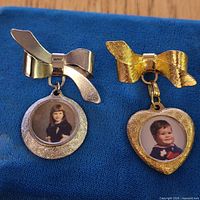 Front view of both brooches showing bow tops and dangling photo frames