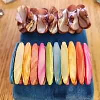 Two shell stretch bracelets laid flat showing colours and style