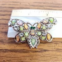Front view of butterfly brooch next to ruler showing width