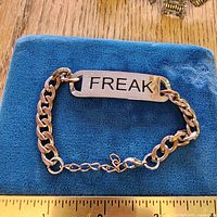 Bracelet on fabric showing ID plate and chain