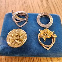 All four brooches on display pad