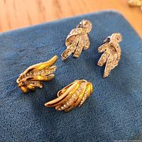 Both pairs of earrings on blue pad