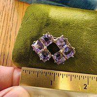Top view showing arrangement of four square purple glass stones and silver beads, ruler for scale