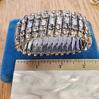 Front view of stretch bracelet on display showing rhinestone rows and ruler for width reference