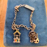 Full bracelet on blue surface showing charms and chain