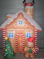 Front view of fully inflated gingerbread house with Santa, Christmas tree and candy cane