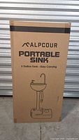 Front of boxed Alpcour portable sink showing branding and sink graphic