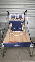 Full view of assembled double hoop arcade basketball game with two balls on ramp