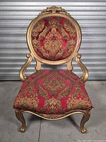 Front view of gold framed red brocade accent chair