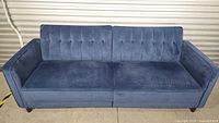 Front view of navy blue velvet sleeper sofa in upright seating position