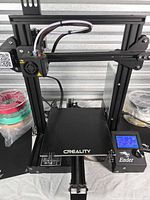 Front view of Creality Ender-3 Pro printer with control box powered, showing overall condition and accessories nearby