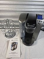 Coffee maker, carousel holder, manuals shown together