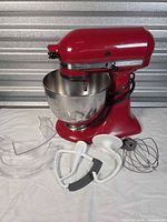 Mixer front view with bowl and all attachments displayed