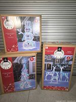 Boxed prismatic snowman, tree, and deer family décor pieces