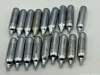 Group of 18 steel CO2 cartridges laid out