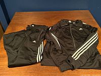 Full view of track suit jacket and pants laid flat