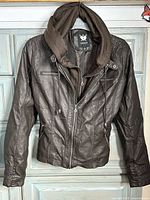 Front view of brown faux leather jacket hanging