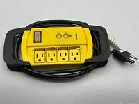 Front view showing four outlets, switch, GFCI buttons and cord wrap