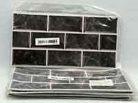 Stack of sealed backsplash tile packs showing front design and barcode label