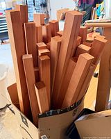 Box containing multiple square 2x2 redwood lumber pieces of varying lengths